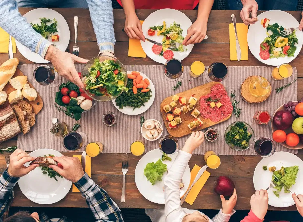 People enjoying a meal together at a table with various dishes and drinks.